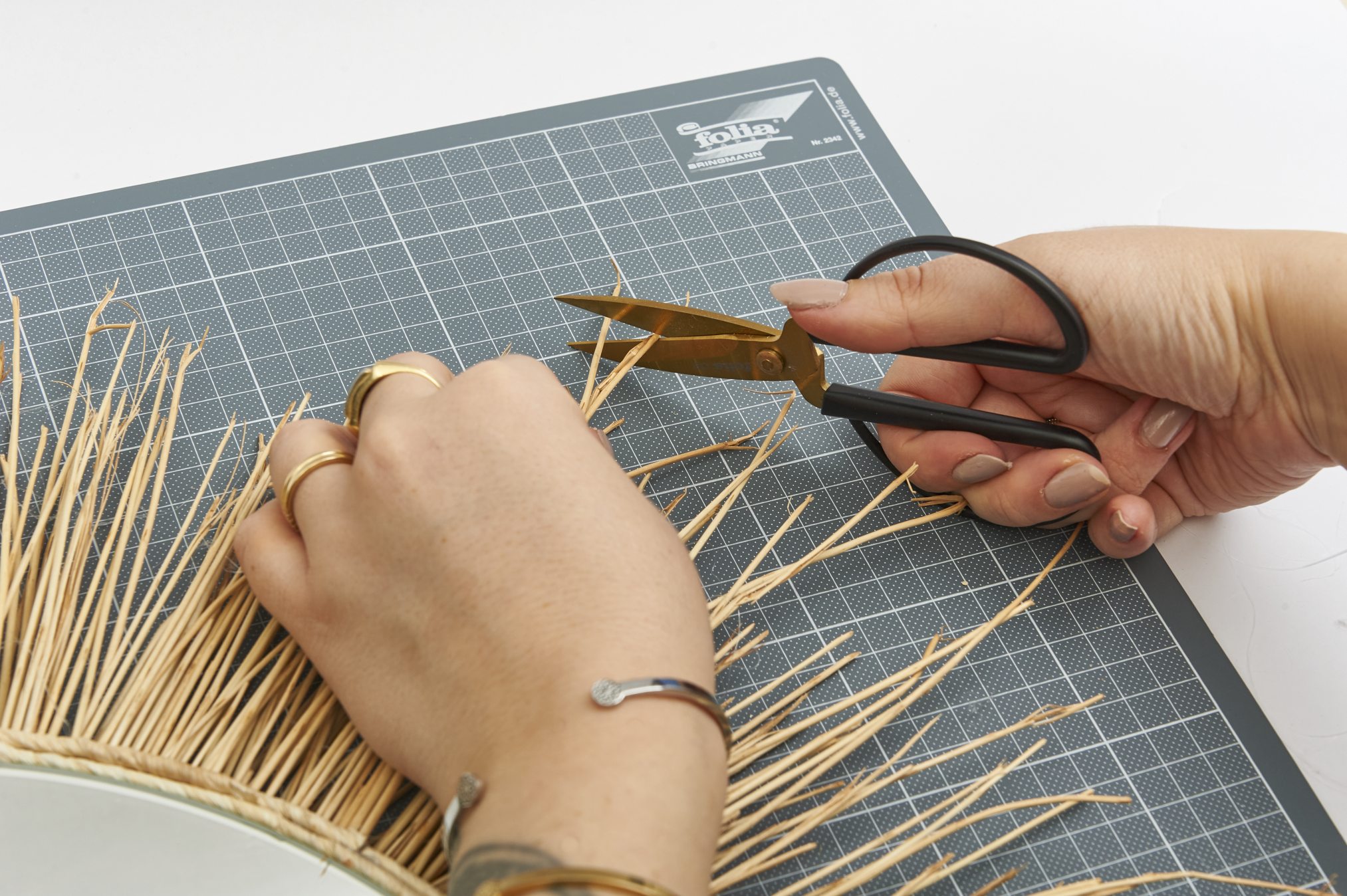 Natürliche Baststruktur, goldene Accessoires, handgefertigt; DIY, kreativ, einzigartige Gestaltung.