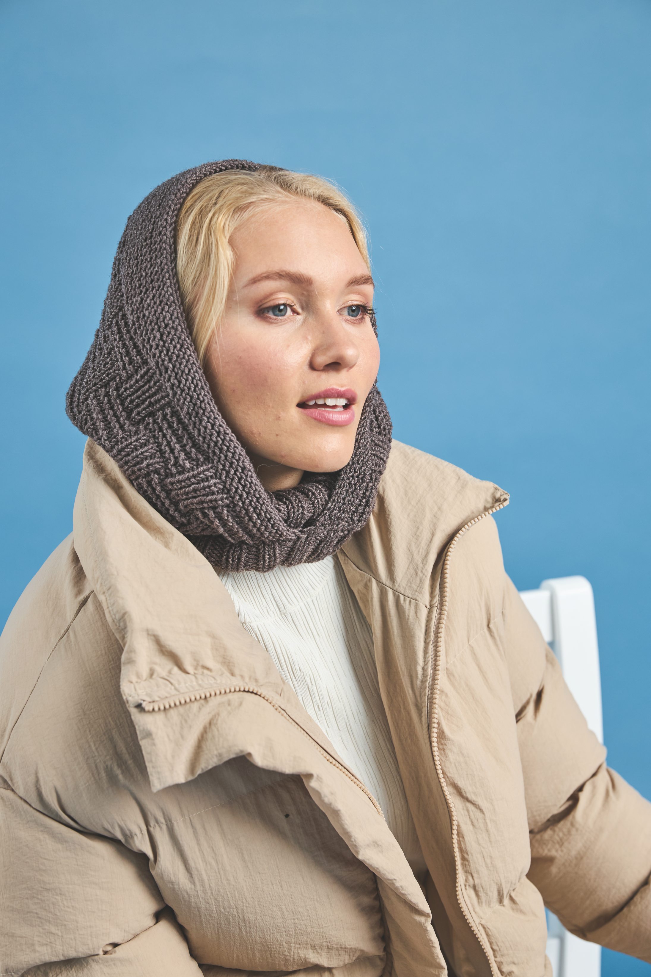 Handgemachter, grauer Kapuzen-Schal zu beiger, gepolsterter Jacke. Modisch, stilvoll, gemütlich.
