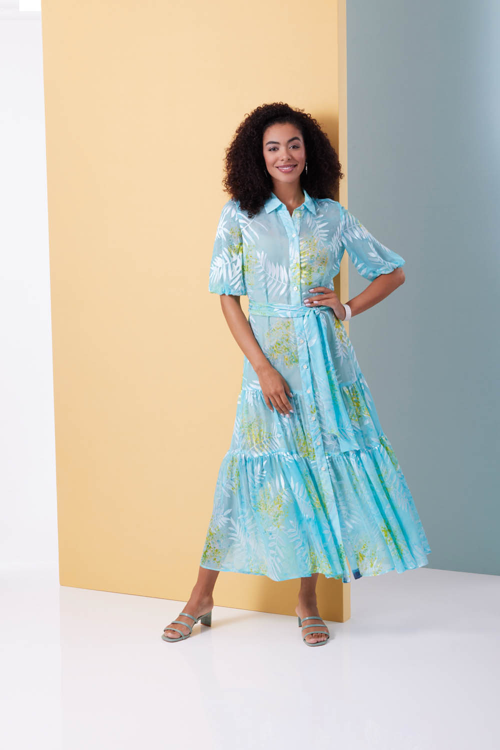 Langes, blaues Kleid mit floralem Muster, tailliert, Kurzarm, modisch, fließend.