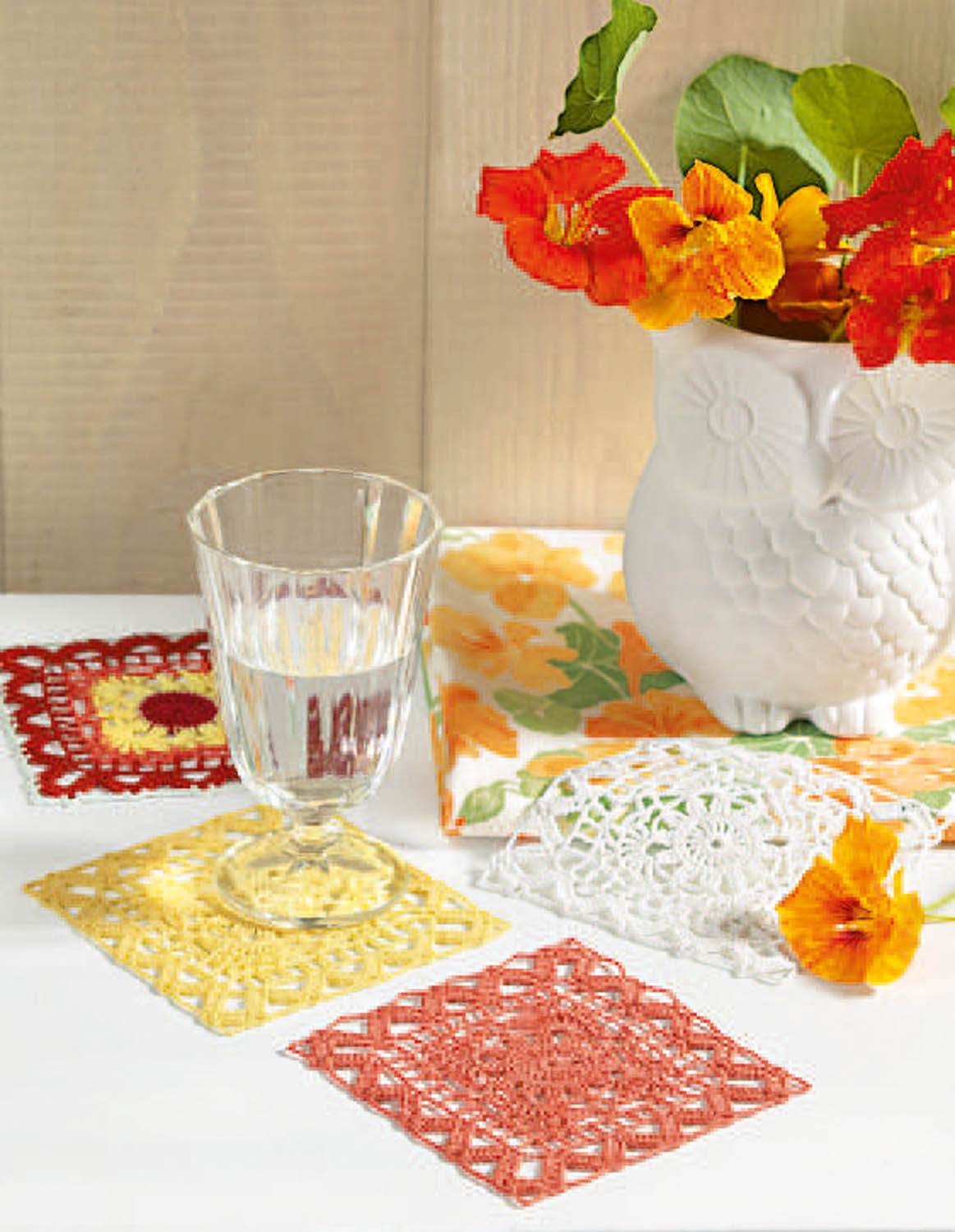 Bunte, gehäkelte Untersetzer in Rot, Gelb, Weiß; kunstvoll, detailreich, DIY-Design.