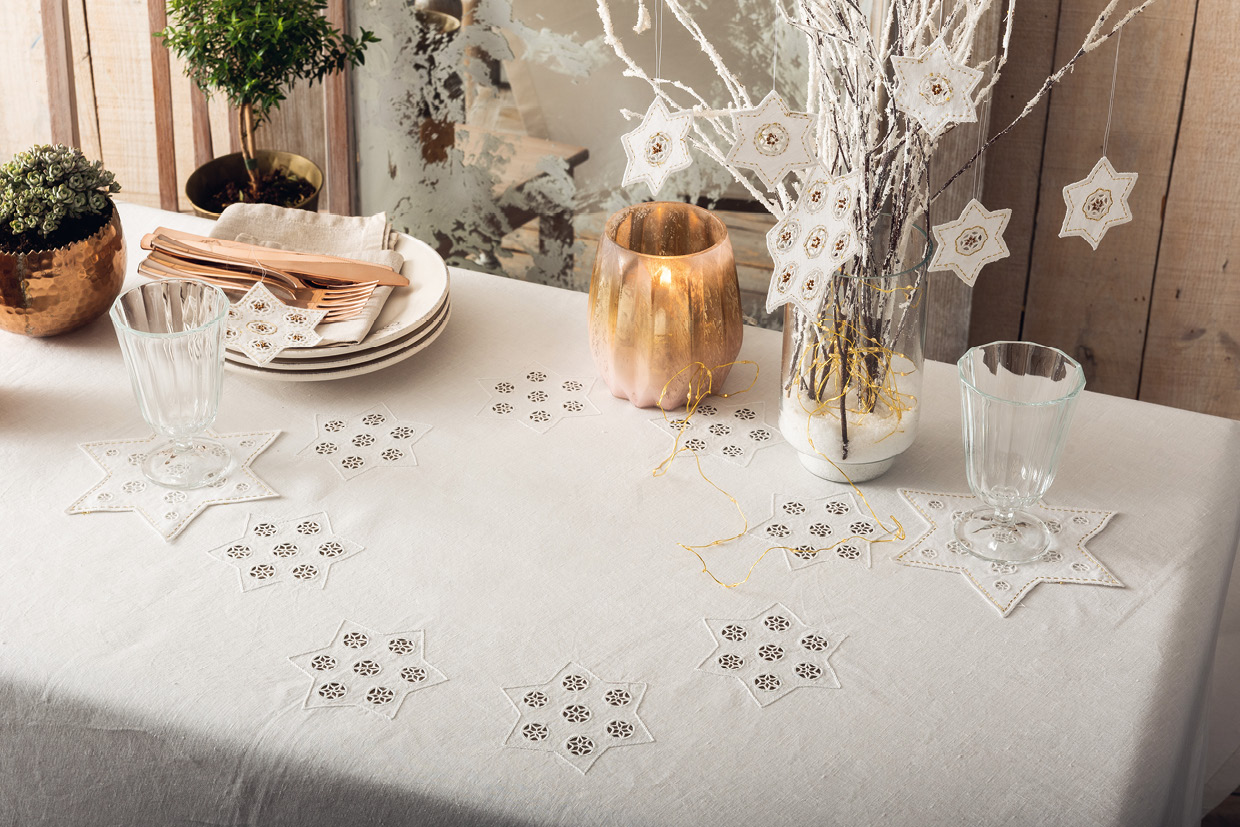 Modellansicht Bild 1: Mit Sternen bestickte Tischdecke, Sternenuntersetzer und -anhänger sowie Stulpen
