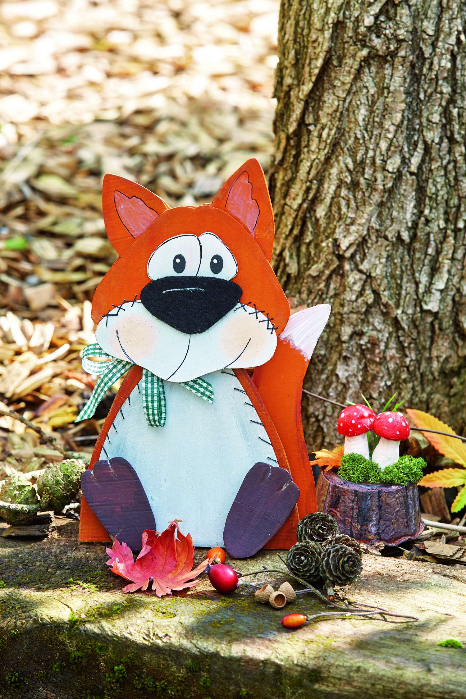Handgemachter Fuchs aus Holz, leuchtend rot, genähte Details, mit grün-weißem Schleifenakzent, modern und charmant.