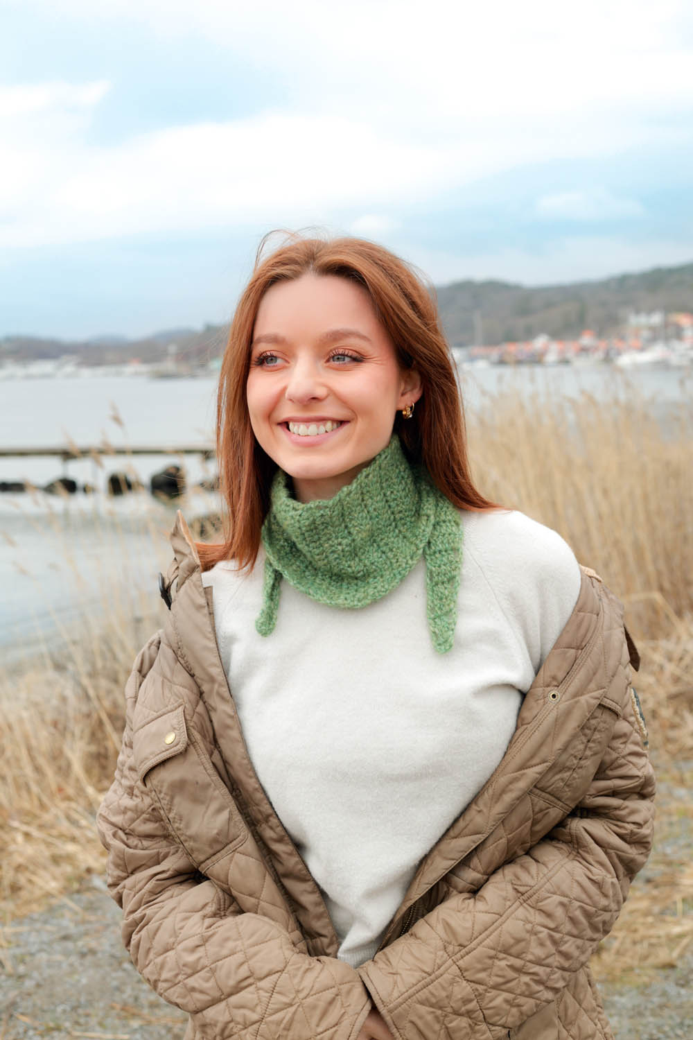 Grüner handgestrickter Rollkragen, cremefarbener Pullover, gesteppte braune Jacke, natürlicher Charme, modisch.