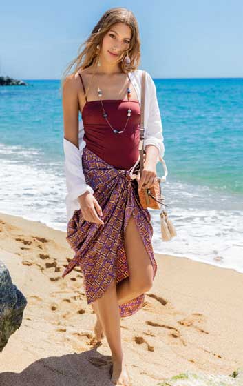 Dunkelroter Badeanzug, gemusterter Pareo, weißes Leinenhemd, modisch, lässig, sommerlich.