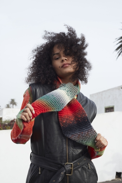 Bunter selbstgemachter Strickschal kombiniert mit schwarzer Lederjacke. Farbenfrohes DIY-Accessoire.