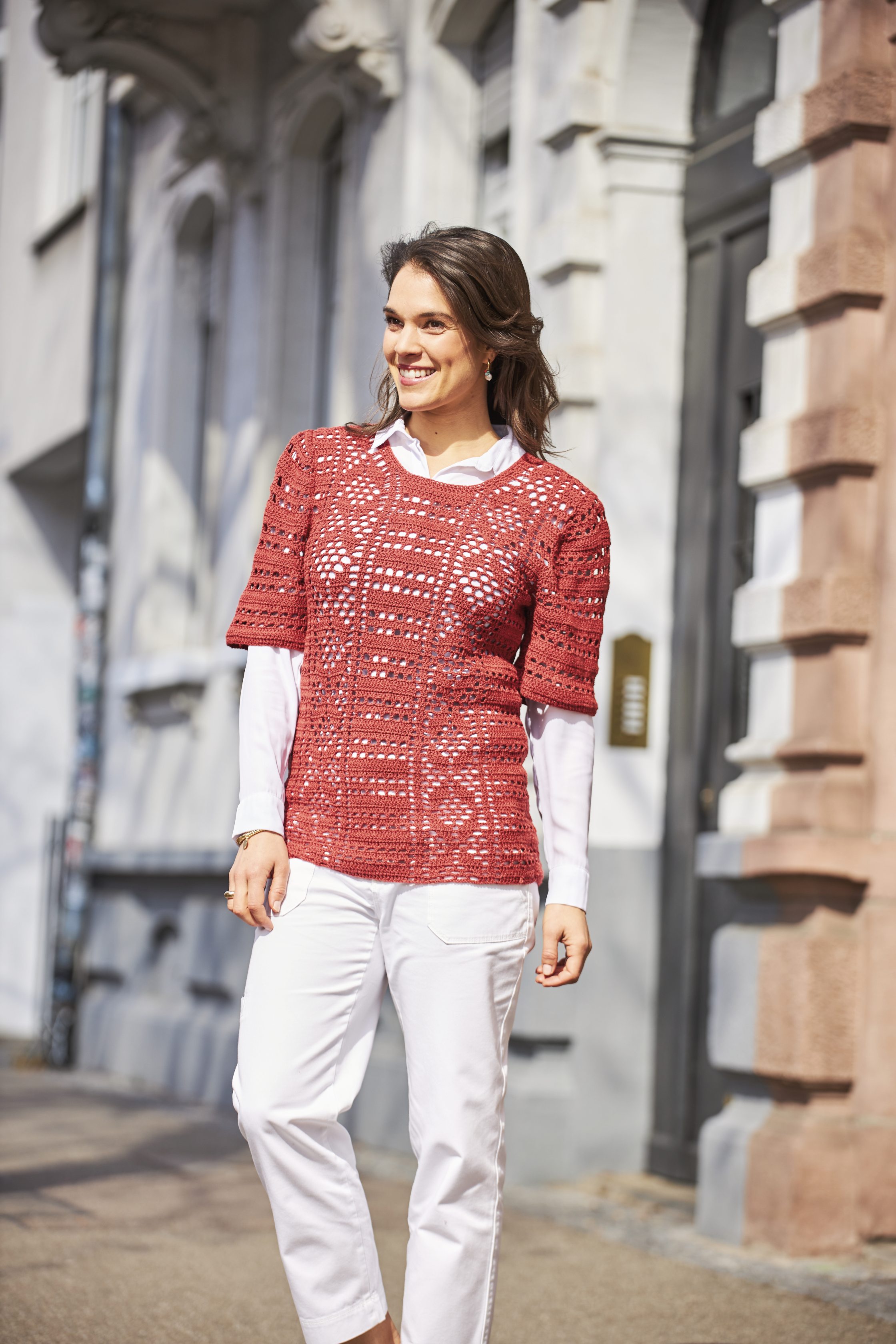 Rotes, gehäkeltes Oberteil, modern und handgemacht. Kombiniert mit weißem Hemd und Jeans. Stilvoll und individuell.