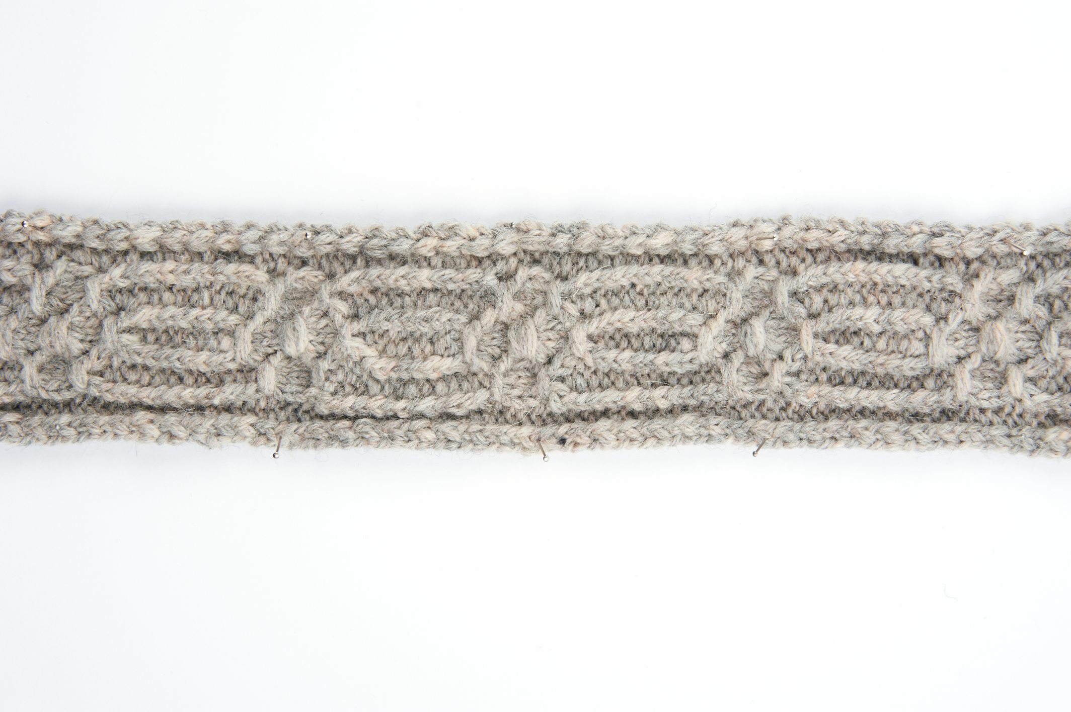Grau-beige, handgemachter Gürtel mit Zopfmuster. Dichtes Gewebe, modisches Design. Perfekt für DIY-Projekte.