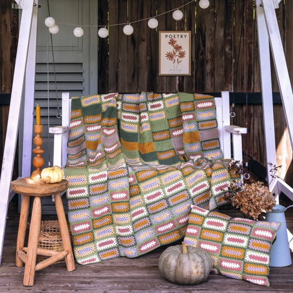 Handgemachte, farbenfrohe Häkeldecke und Kissen in Streifenmuster. DIY, rustikal und gemütlich.