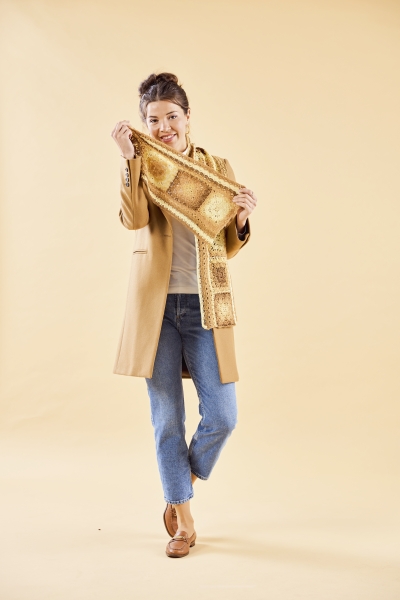 Handgemachter, gemusterter Schal; camel Mantel, blaue Jeans. Modischer, lässiger Look.
