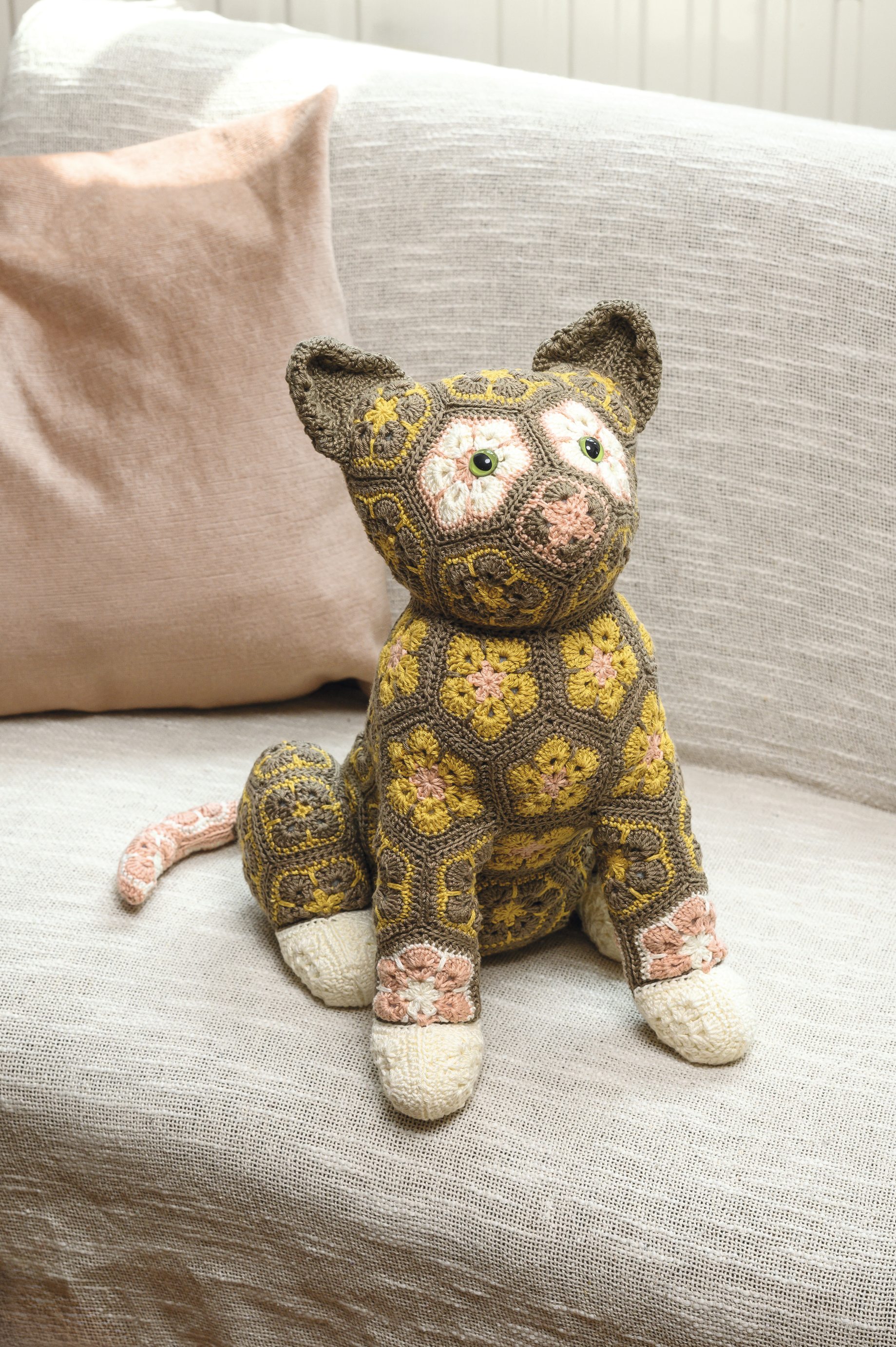 Bunte, handgemachte Katze mit Blumenmuster, warme Farben, ausgefallene Fertigung, modisch und kreativ.