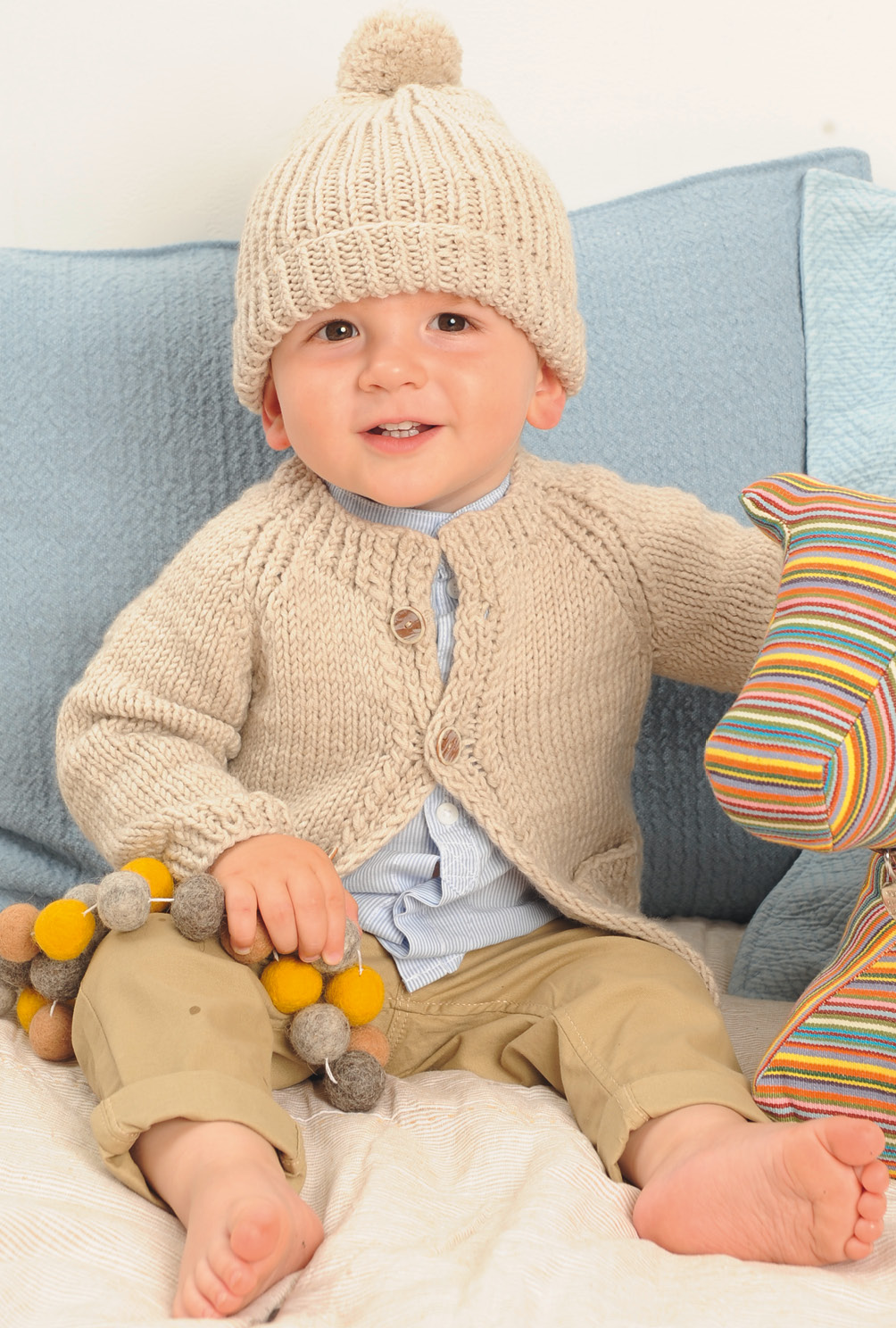 Beigefarbene Jacke  und rosafarbener Pulli mit Mütze