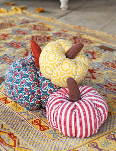 Bunte DIY-Stoffkürbisse: rot-weiß gestreift, gelb gemustert, blau geblümt; modisch, handgemacht, herbstlich.