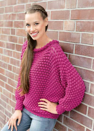 Modischer pinker Strickpullover mit voluminösem Muster und lässigem Schnitt. Handarbeit trifft Stil.