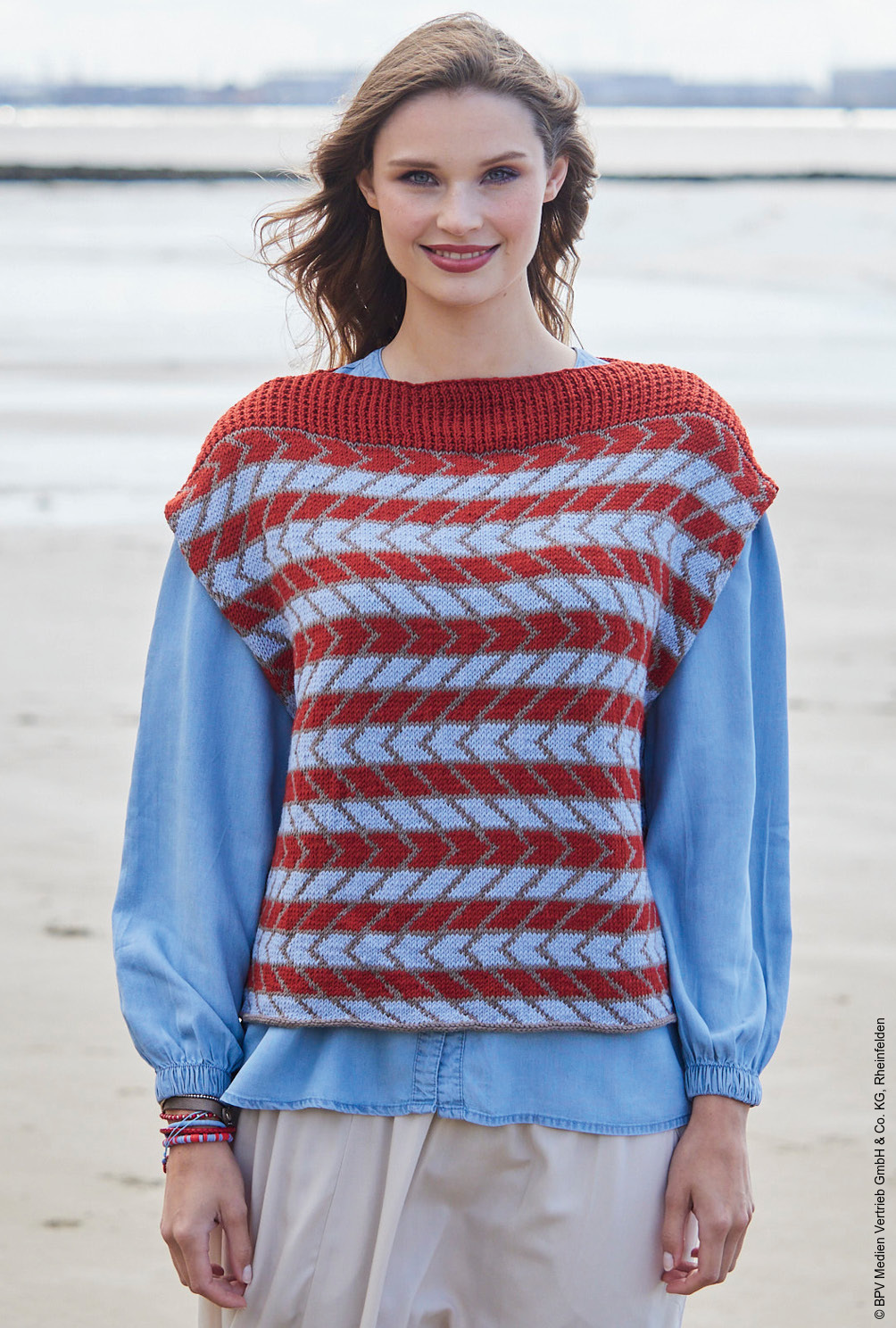 Modellansicht Bild 2: Oversize Pullunder im Jacquardmuster in Rot, Taupe und Hellblau