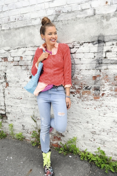 Rote Spitzenbluse, helle Jeans mit Rissen, bunte Stiefel; modischer DIY-Charme mit handgemachtem Flair.