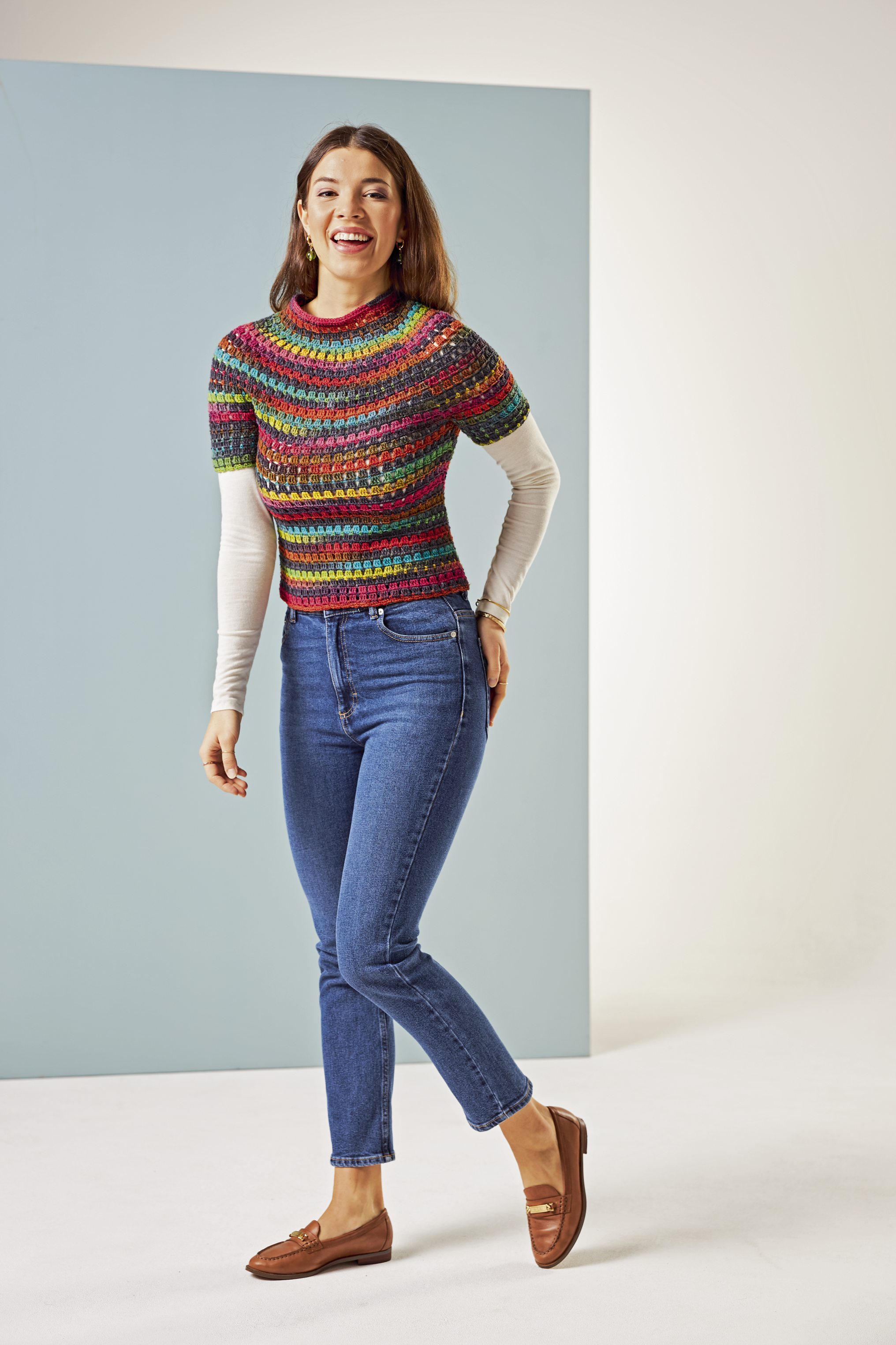 Modischer, handgemachter Pullover: bunt gestreift, figurbetont; Basic-Jeans, lässig. DIY-Charakter, lebendige Farben.