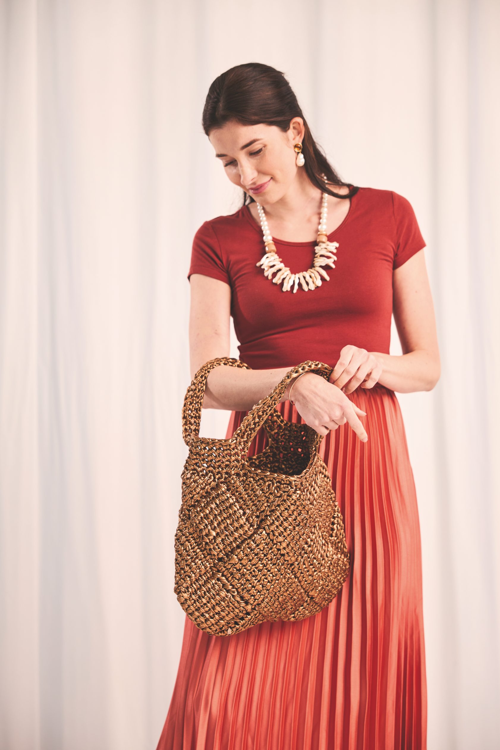 Rotes Kleid mit fließendem Faltenrock. Handgewebte Tasche, natürliche Accessoires. Boho, stilvoll, DIY.