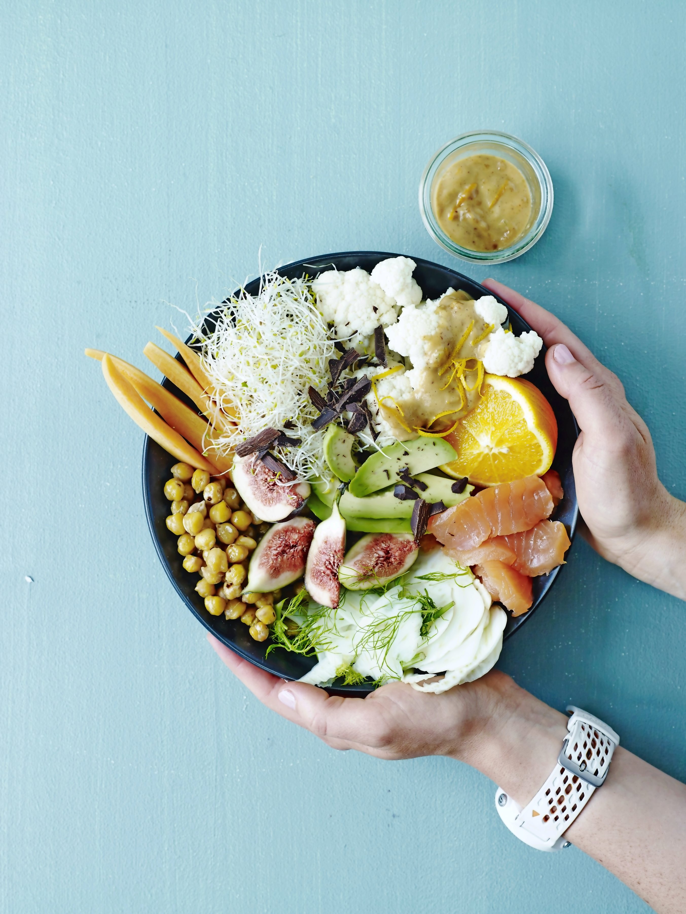 Bunte Schüssel mit vielfältigen Zutaten: Lachs, Feigen, Kichererbsen. Frisch, kreativ, trendig.
