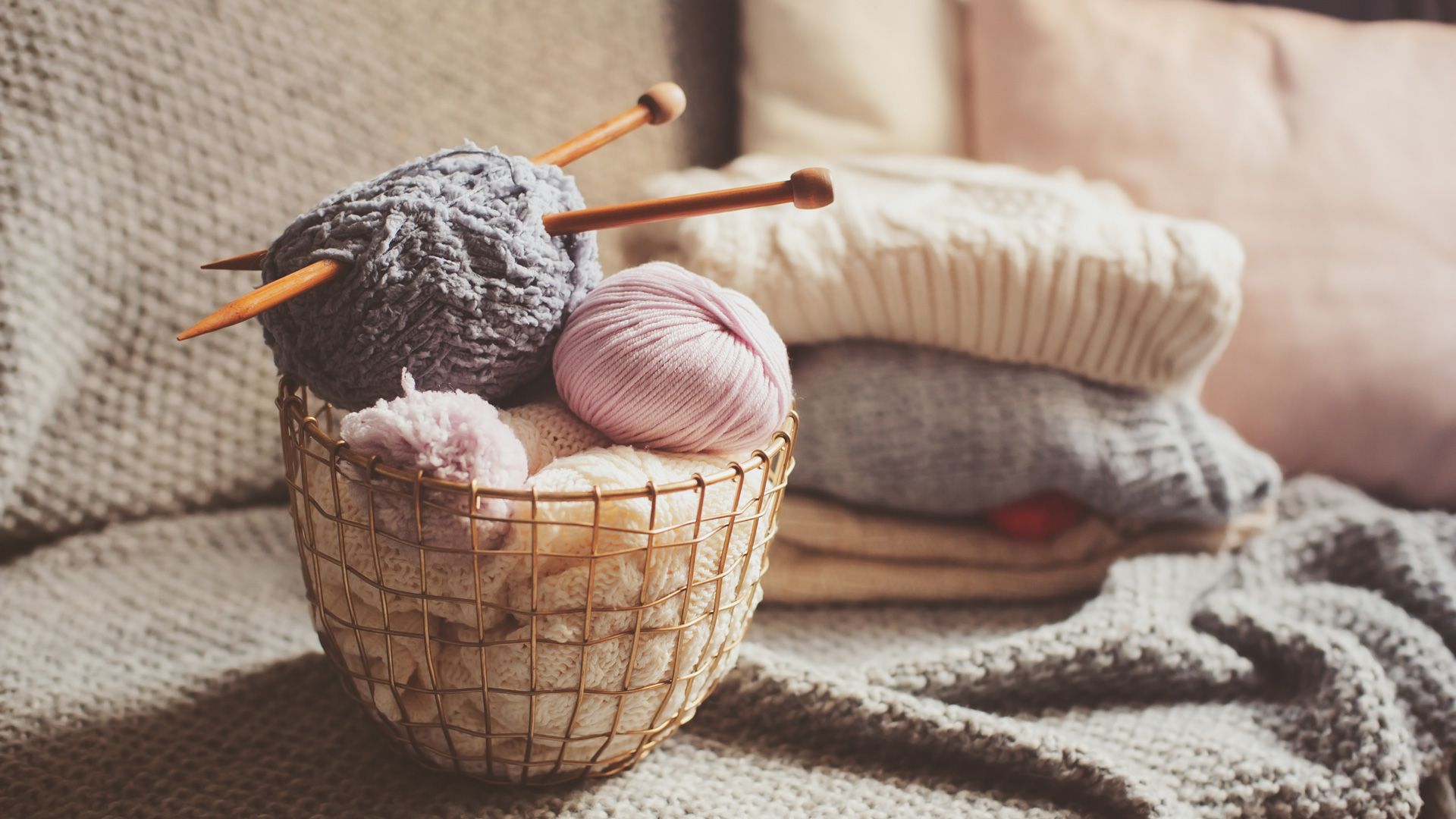 Gestrickte Pullover in sanften Farben, DIY-Stil, ergänzt durch Wolle in Pastelltönen, rustikal und handgemacht.