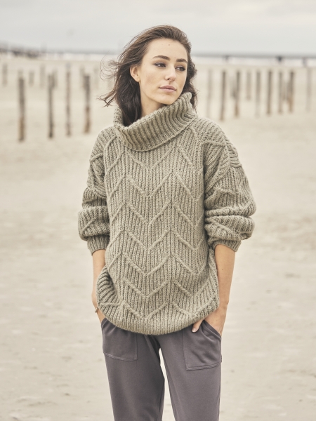 Modischer, handgestrickter Pullover mit Zopfmuster in Beige, hoher Kragen, lässiger Schnitt. DIY-Stil.