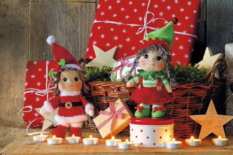 Handgemachte Puppen in Rot und Grün, gestrickte Kleider mit feinen Mustern. DIY-Charme trifft auf Weihnachtsflair.