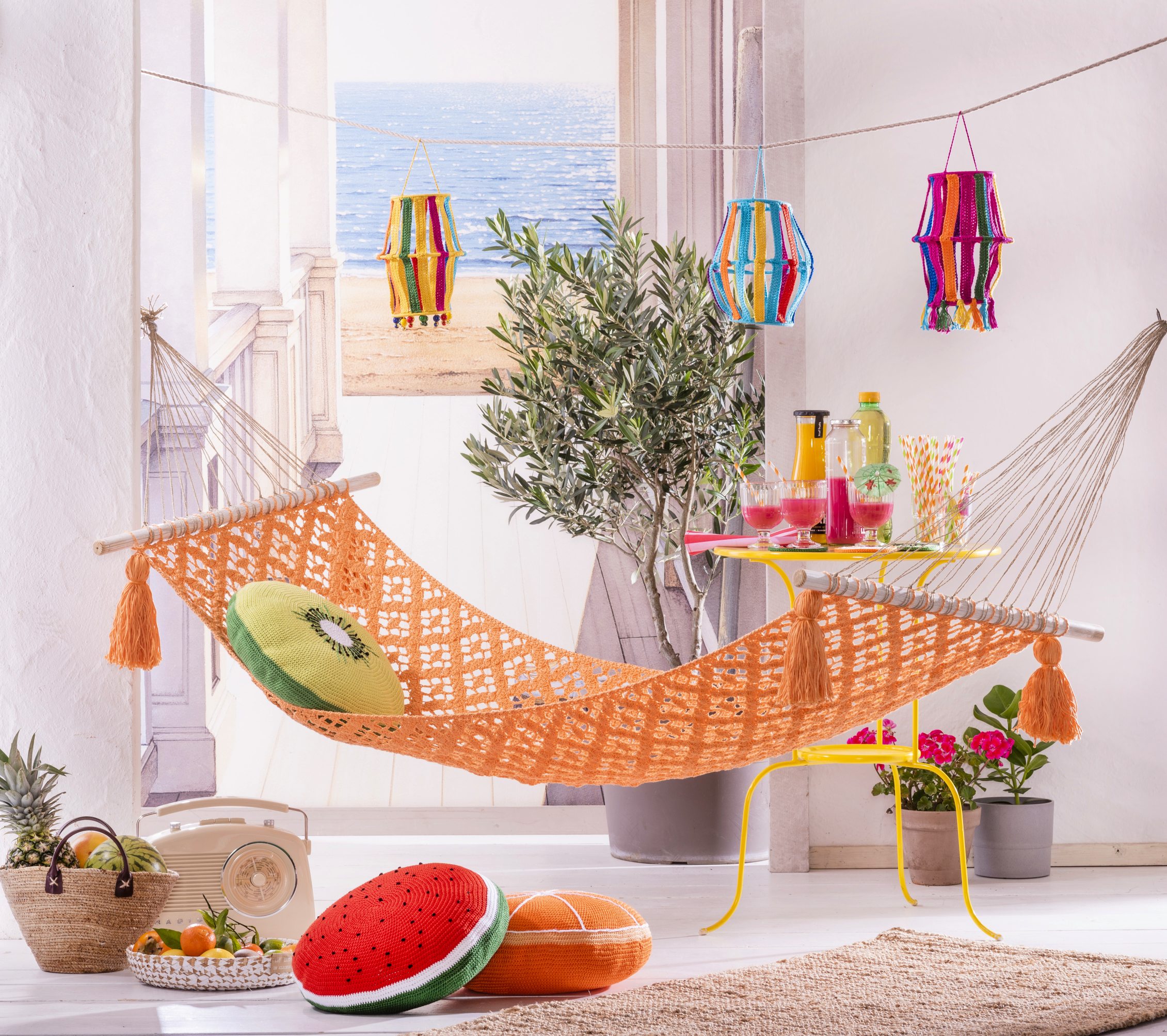 Orange, gehäkelte Hängematte mit Fransen; bunte Kissen im Obstdesign. DIY, handgearbeitet, farbenfroh.