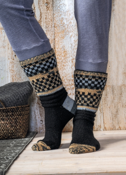 Schwarze Socken mit modischem, mehrfarbigem Muster. Handgestrickt, DIY-Stil, warmes Design.