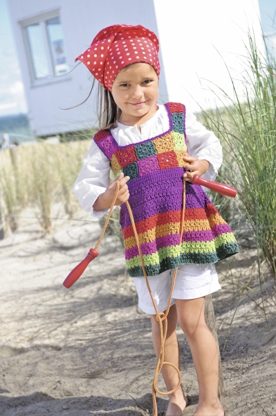 Handgemachtes Kleid, bunt gestreift, gehäkelt, quadratische Muster. Rot-gepunktetes Kopftuch, modisch.