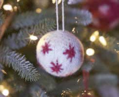 Weiße Kugel mit roten Sternmustern, handgestrickt, kunstvoll, festive DIY-Dekoration.