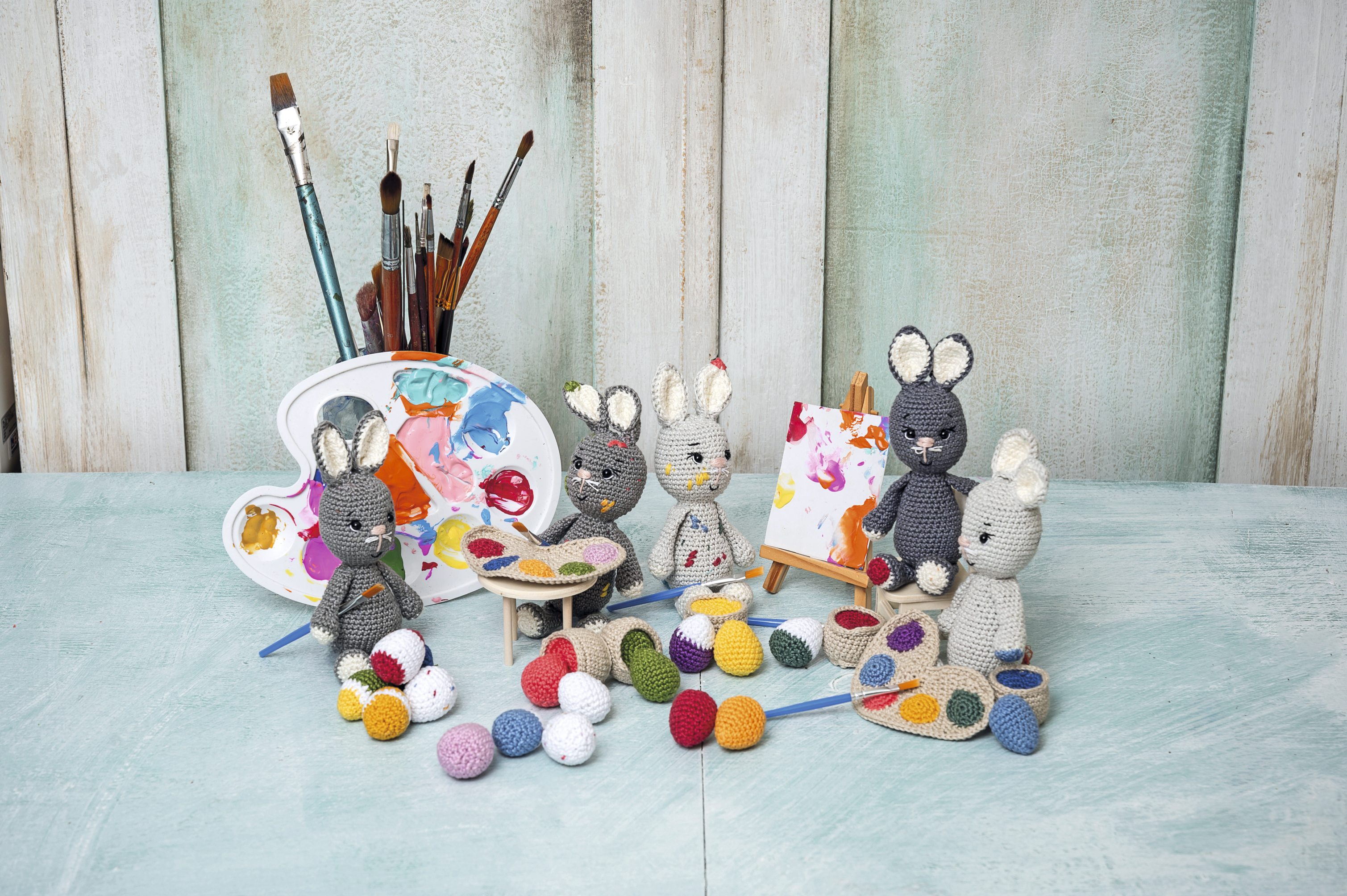 Häkelbunnies in grauer und weißer Wolle, DIY-Charme, bunte Akzente, modische Accessoires mit kreativer Note.