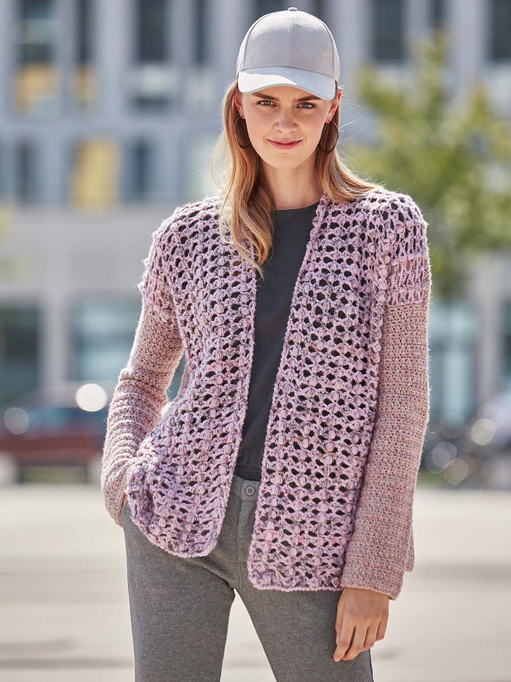 Modellansicht Bild 1: Rosafarbener, gehäkelter Cardigan mit abgesetzten Ärmeln