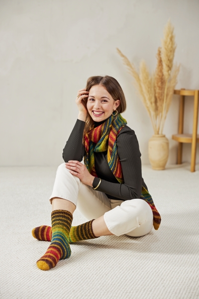 Lebendige, handgemachte Socken im Streifenmuster, kombiniert mit Schal. Modisch und elegant.