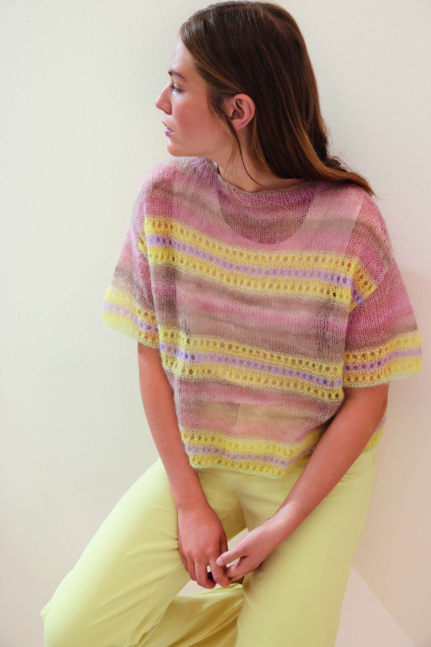 Luftiger, gestrickter Pullover, pastellfarben, kurze Ärmel, gelb-rosa Muster, modisch, handgestrickt.