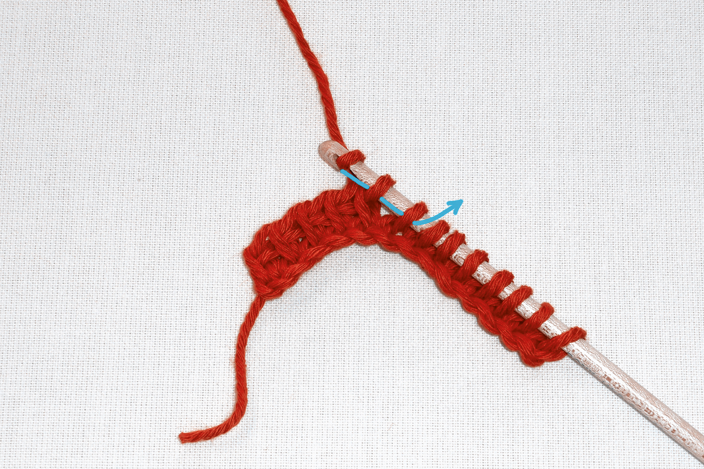 Rotes, selbstgemachtes Strickprojekt mit gleichmäßigem Maschenmuster. Handarbeit, diy, detailreich.