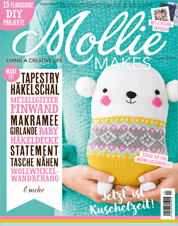 Bunt gestrickte DIY-Wärmflaschenhülle. Verspielte Muster in Weiß, Gelb, Grau. Modischer und selbstgemachter Look.