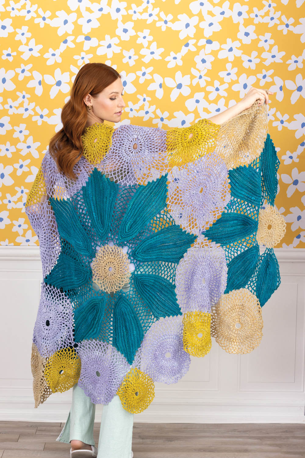 Bunte, handgemachte Häkeldecke mit floralem Muster. Farben: Türkis, Violett, Gelb. Modisch und einzigartig.