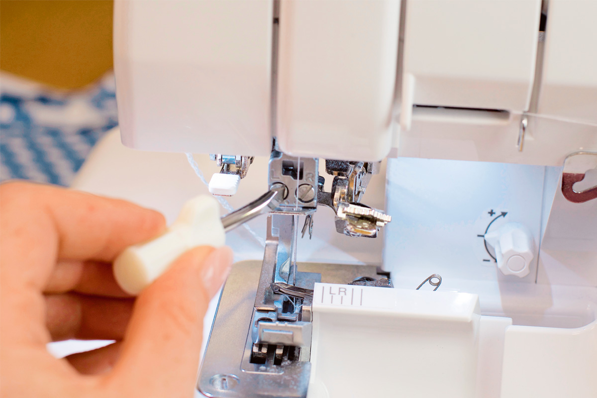 Nahaufnahme einer weißen Nähmaschine, perfekt für DIY und handgemachte Projekte. Präzise Handhabung.