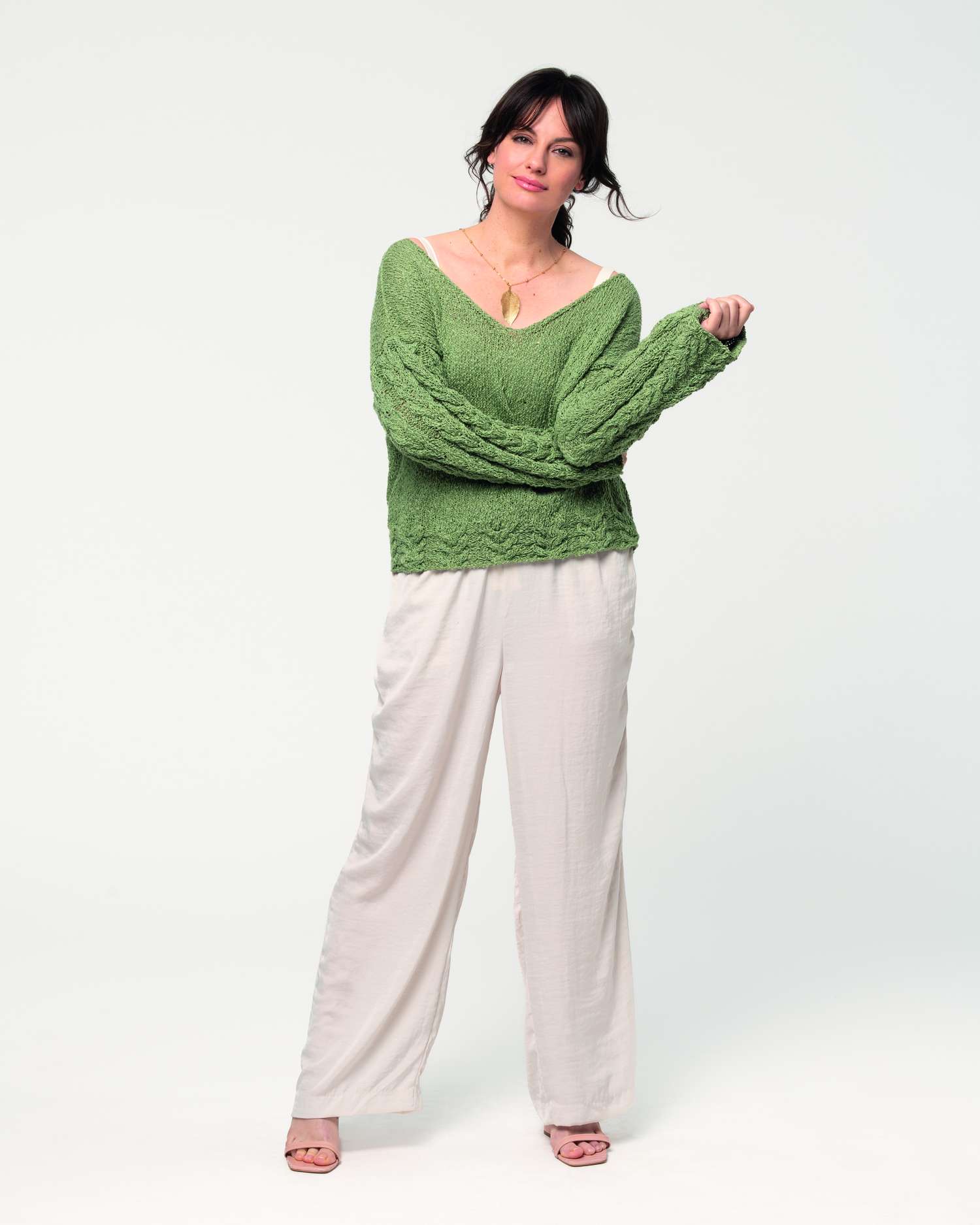 Grüner Strickpullover, weit geschnitten, kombiniert mit lockerer weißer Hose. Modisch & gemütlich.