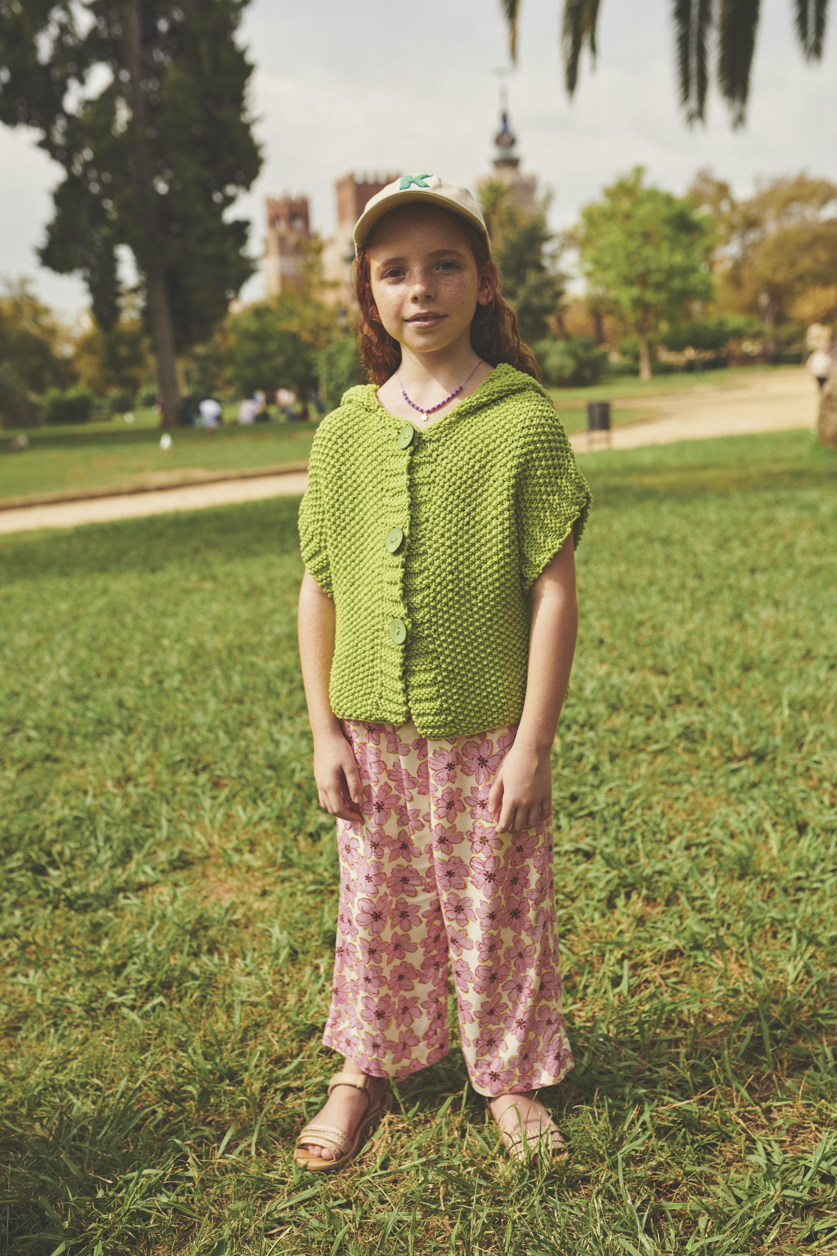 Grünes, selbstgemachtes Strickoberteil, florale Hose in Rosa. Lässiger, handgemachter Look mit freiem Schnitt.
