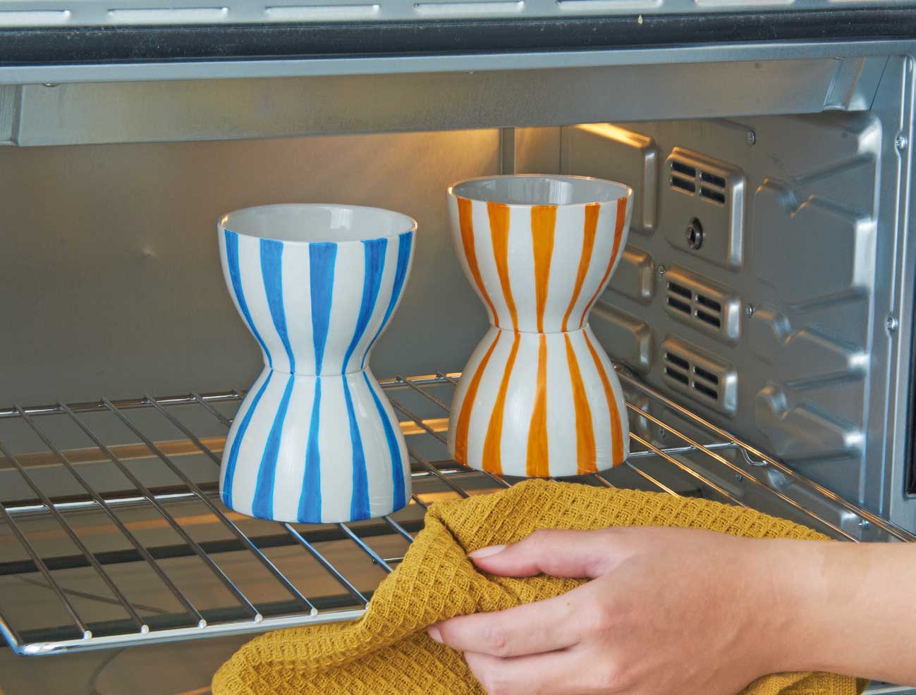 Handgemachte Vasen mit blau-weißen und orange-weißen Streifen. Modisches Design mit DIY-Charakter.