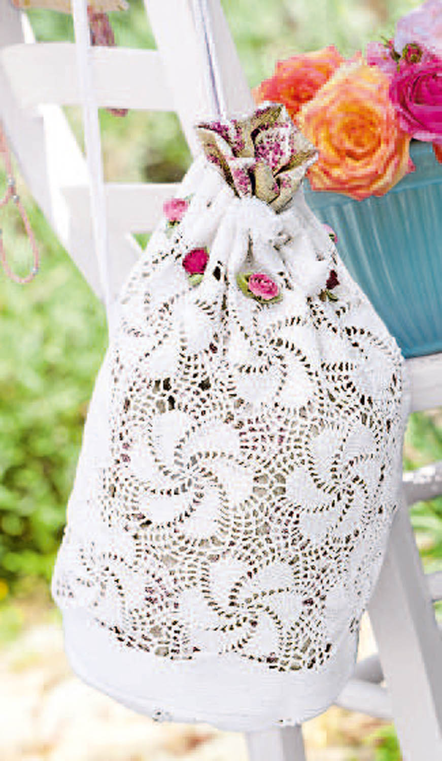 Weiße, gehäkelte Tasche mit Wirbelmuster. Handgemachte Details und Rosenelemente für einen romantischen Touch.