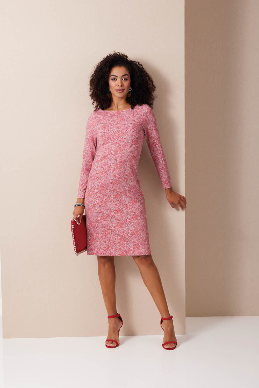 Rotes Kleid mit fein gemustertem Stoff, figurbetontem Schnitt, langen Ärmeln. Modisch und stilvoll.