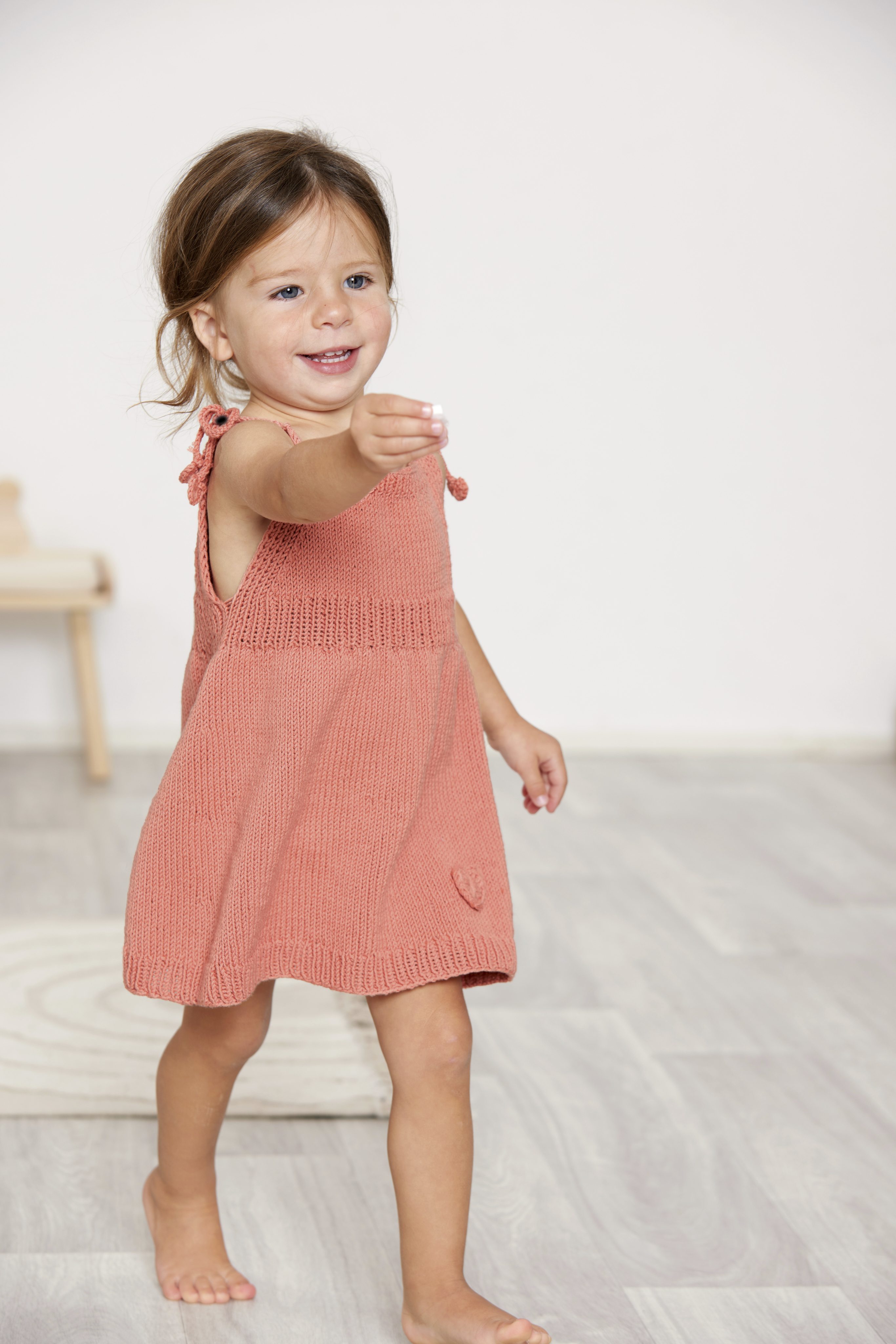 Charmantes handgemachtes Kleid in Korallenrot, ärmellos, mit feinem Strickmuster; modisch, bequem, einzigartig.