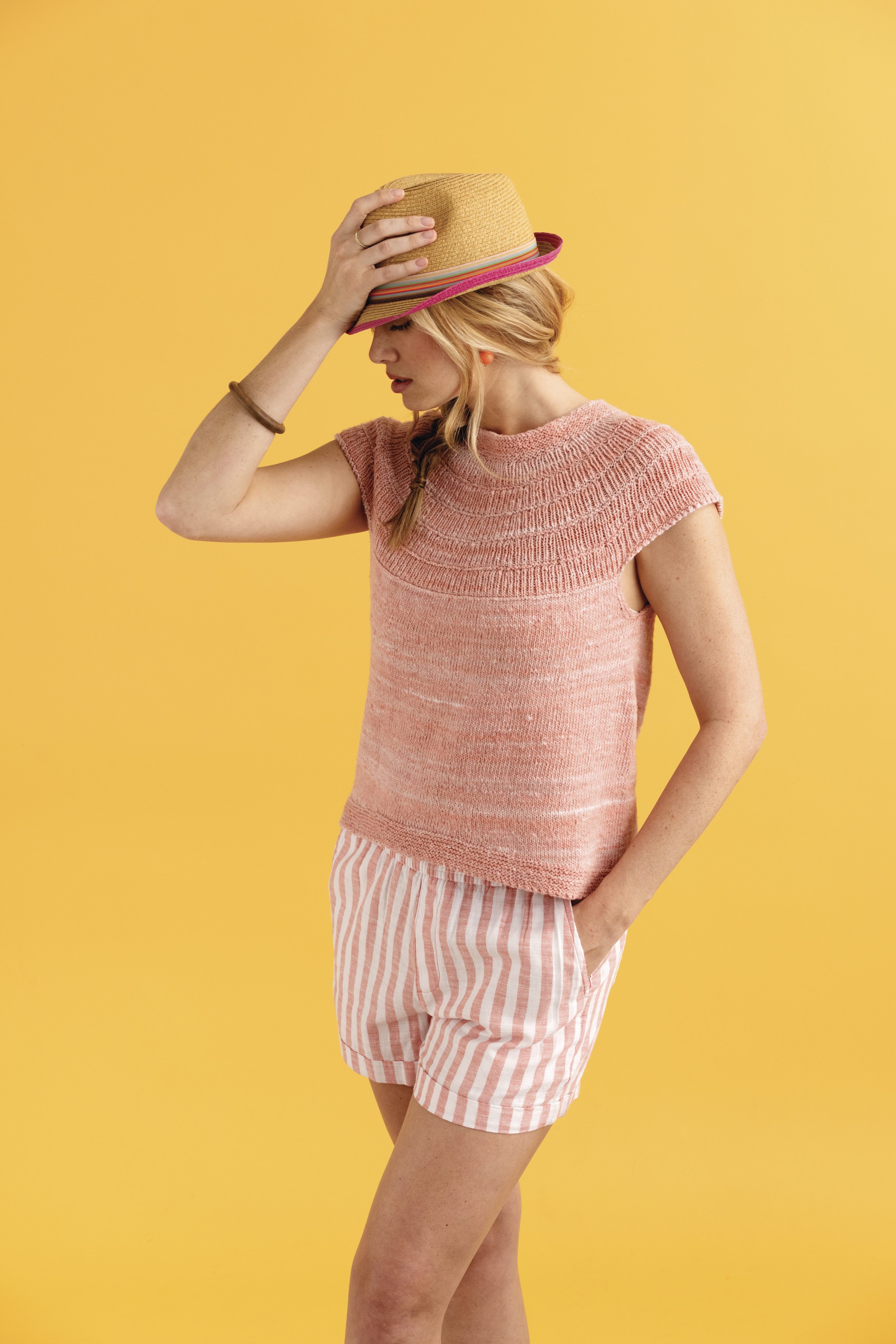 Rosa Stricktop, handgemacht, mit kurzen Ärmeln. Kombiniert mit gestreiften Shorts. Modisch und leicht.