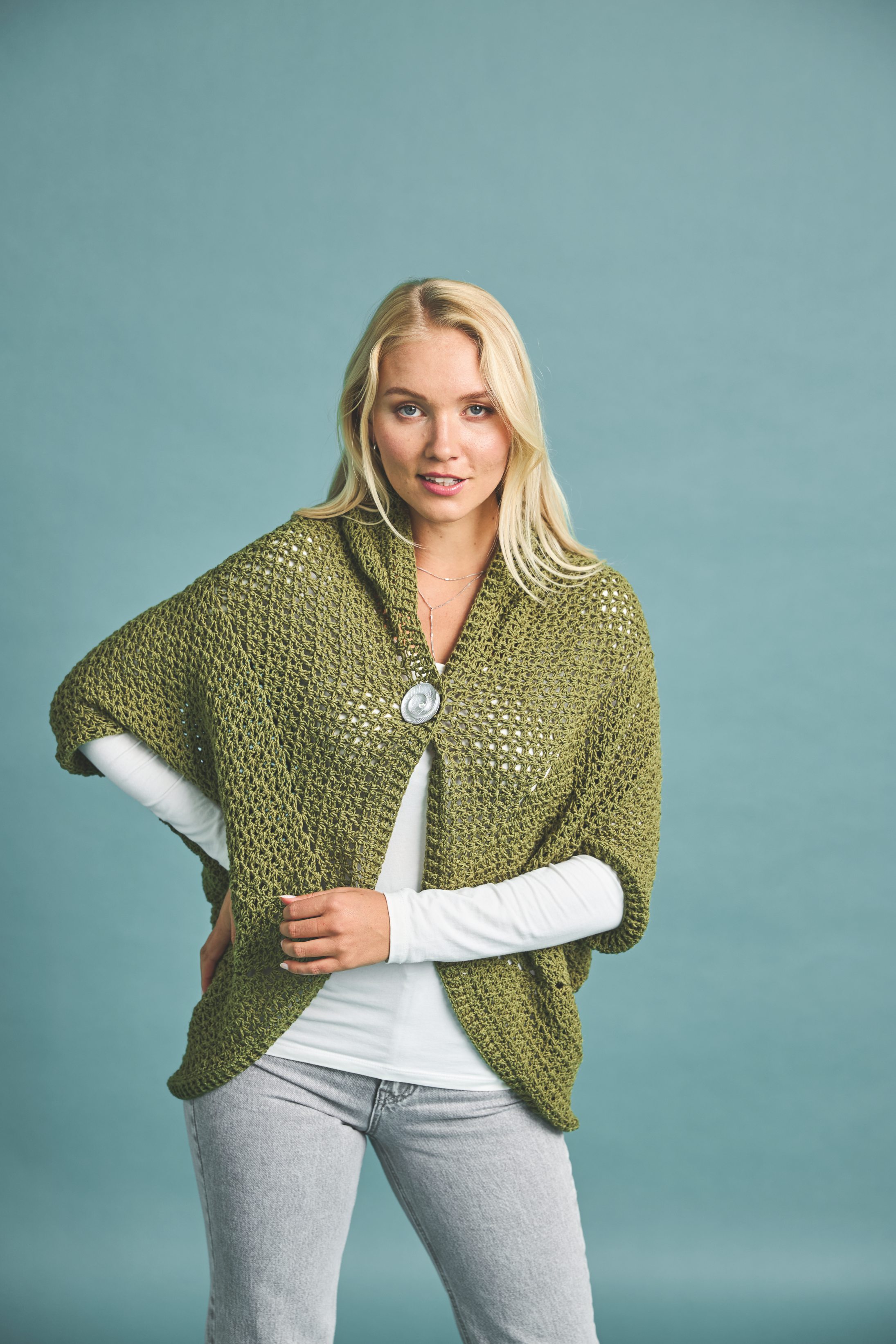 Olivgrünes Strickcape, grobe Maschen, lässiger Schnitt, modisch und handgemacht.
