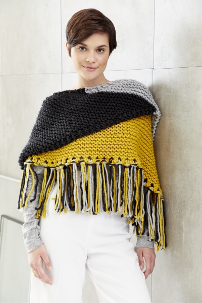 Dreifarbiger, handgemachter Strickponcho in Gelb, Schwarz, Grau. Modische Fransen, asymmetrischer Schnitt. DIY-Chic.