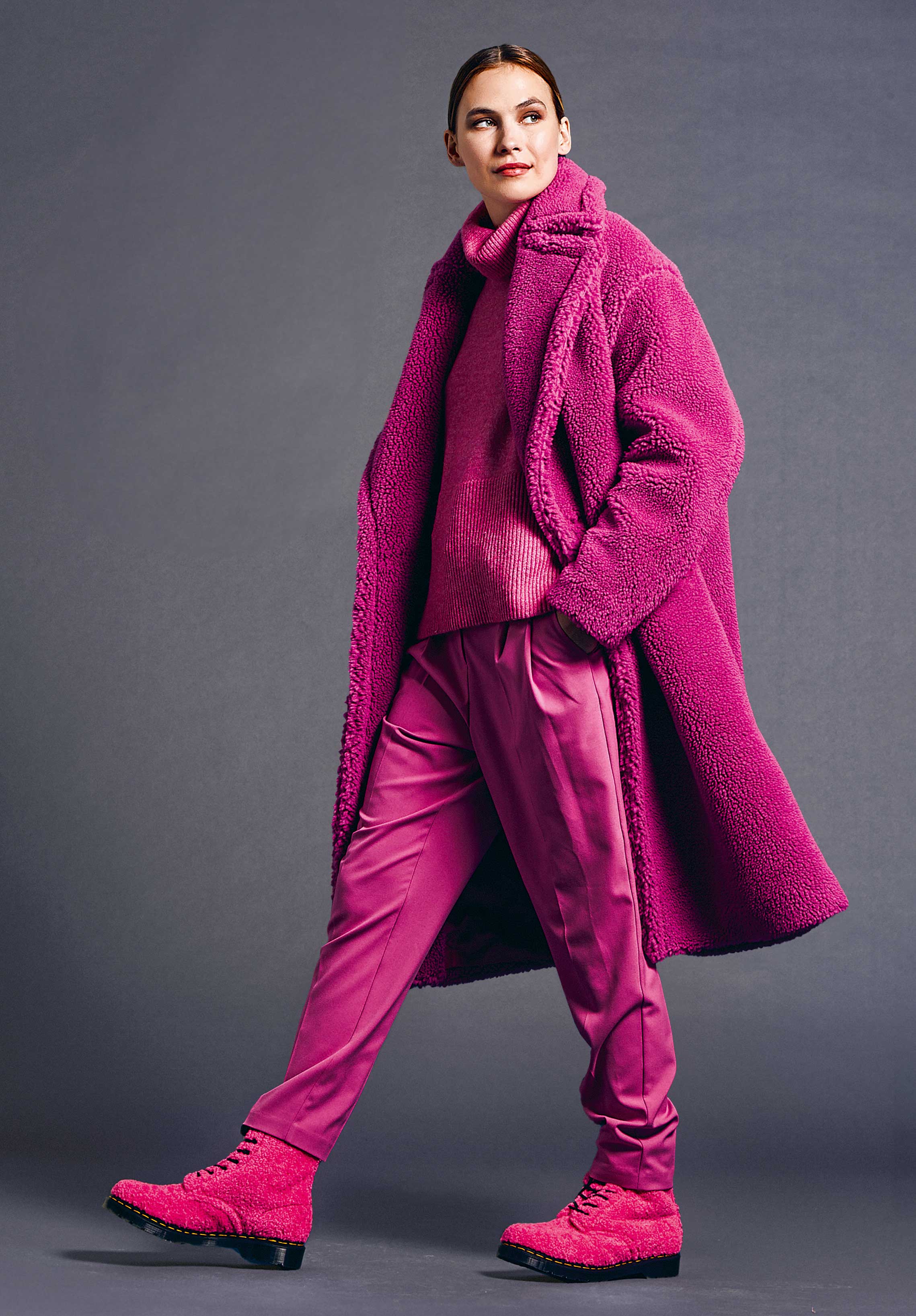 Monochromer Look in fuchsienrosa: Teddy-Mantel, grober Strick, glänzende Hose, stylish, modern, harmonisch.