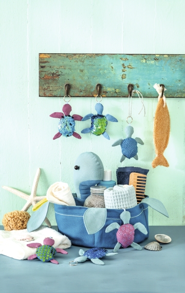 Bunte handgemachte Stofftiere im maritimen Stil. Blau, Grün, Lila Töne. Verspieltes Muster, DIY-Charakter.