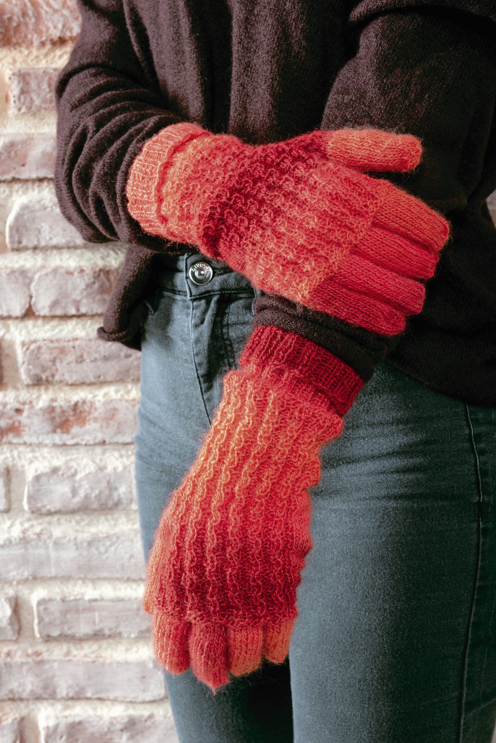 Rote, handgemachte Handschuhe mit grobem Strickmuster. Modisches Accessoire, ideal für kalte Tage.