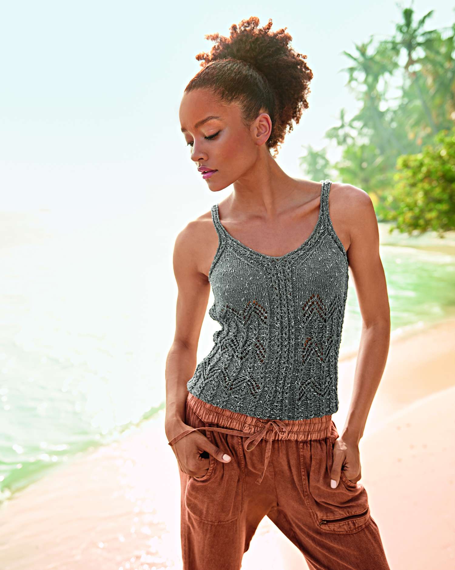 Modisches graues Stricktop mit zarten Mustern, kombiniert mit legerer brauner Hose. Sommerlicher Chic.